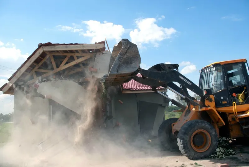 Residents watch an illegal structure being brought down in Harare